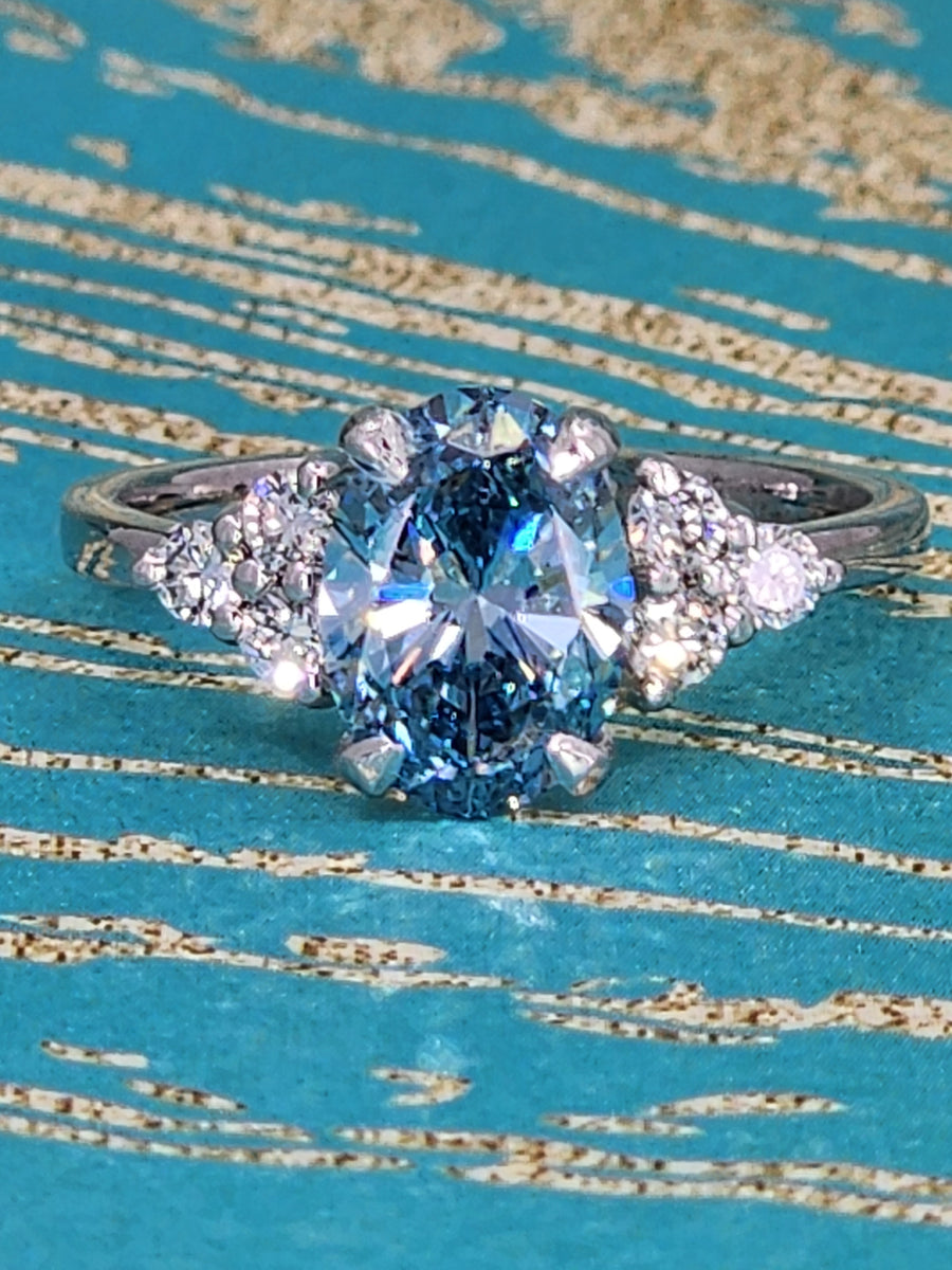 Detailed close-up of the blue lab grown oval cut diamond ring, emphasizing the rich color, high clarity, and expert craftsmanship of the lab diamond.

