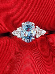 Blue lab grown oval cut diamond ring with a 2-carat center stone, showcasing its brilliance and sleek modern setting in a straight front view.
